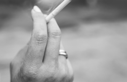 Handing holding a lit cigarette