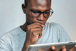 Man wearing glasses reading a tablet