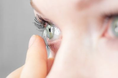 contact lens being inserted into eye