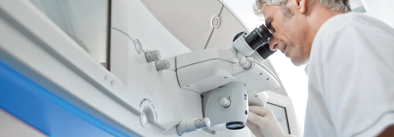 a man looking into binoculars of a visumax laser